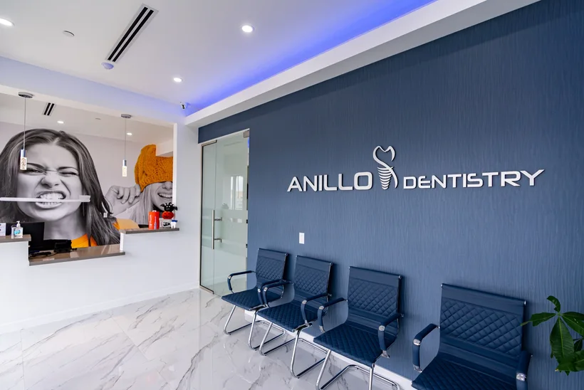 Anillo Dentistry — Sala de espera con letras ANILLO DENTISTRY sobre una pared azul marino y filas de sillas azul marino