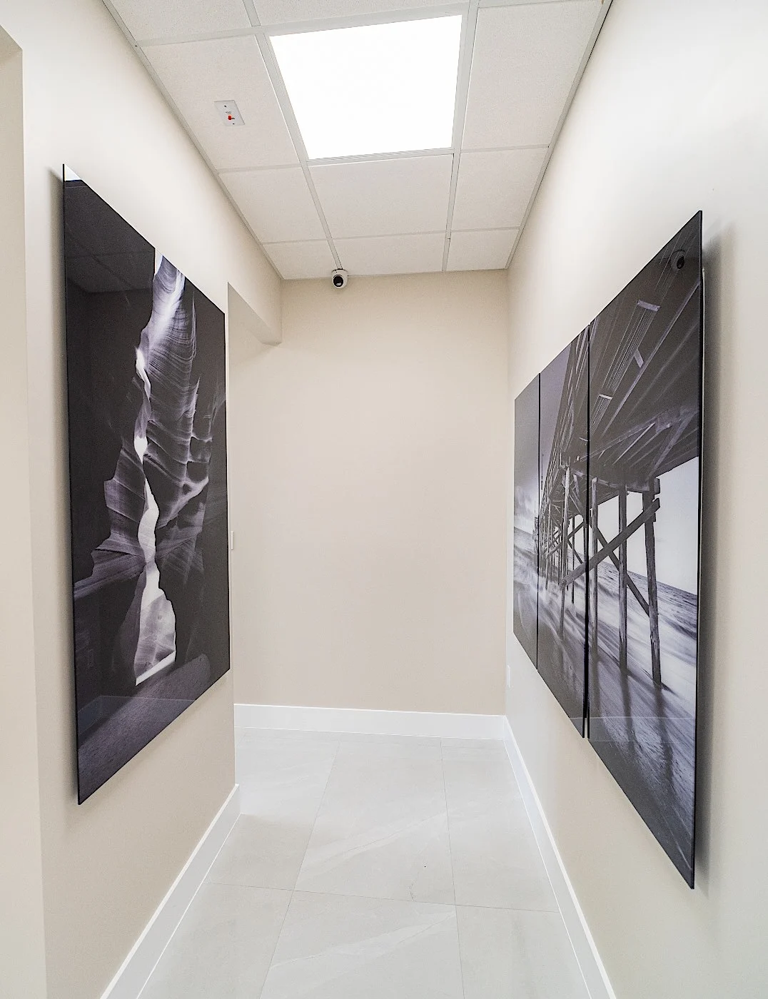 Clear Smiles Dental — Pasillo corto con dos grandes paneles en blanco y negro, uno frente al otro