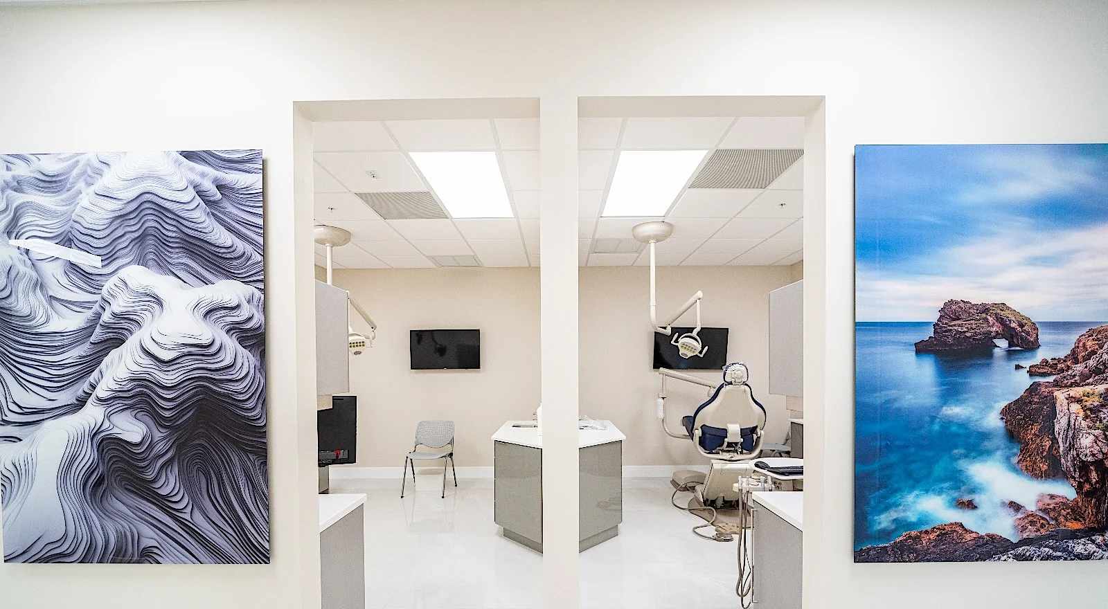 Clear Smiles Dental — Entradas a dos salas de tratamiento, entre un relieve blanco en ondas y una fotografía de costa