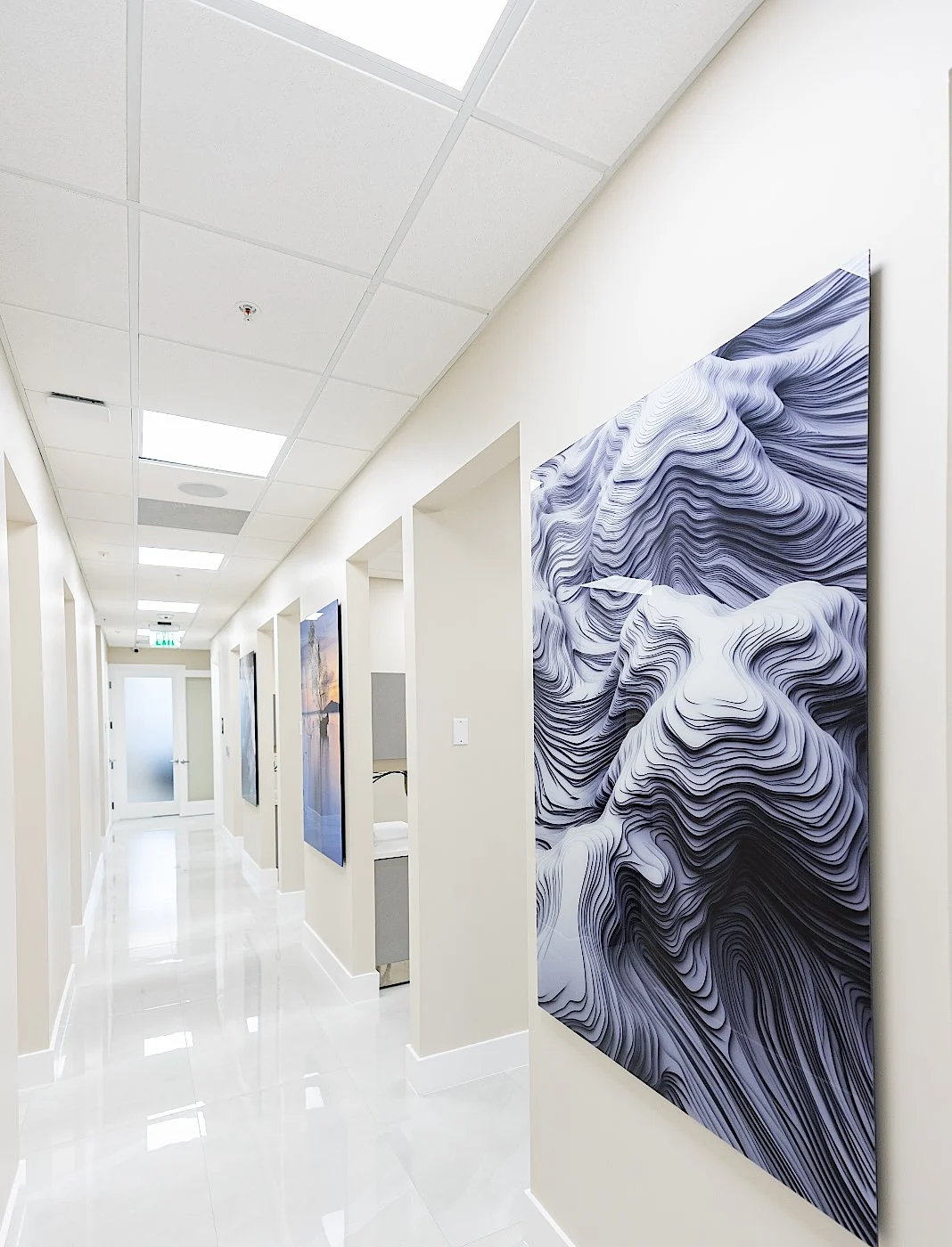 Clear Smiles Dental — Pasillo con un gran relieve escultórico blanco sobre un piso de porcelanato brillante