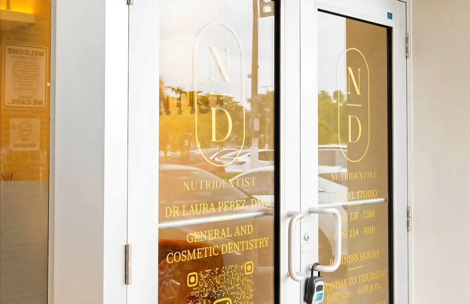 Nutridentist — Puertas de entrada con el monograma N/D dorado, el nombre de la clínica y su horario escritos en el vidrio