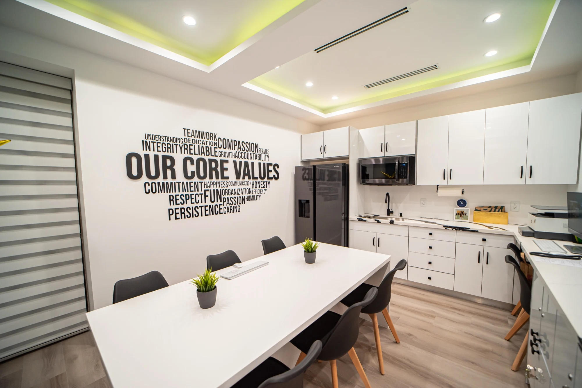Select Dental Care — Sala del equipo con una pared de palabras OUR CORE VALUES, una mesa larga blanca y sillas negras