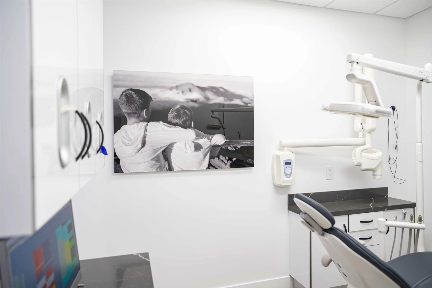 Select Dental Care — Sala de tratamiento con una fotografía en blanco y negro de dos niños mirando las montañas