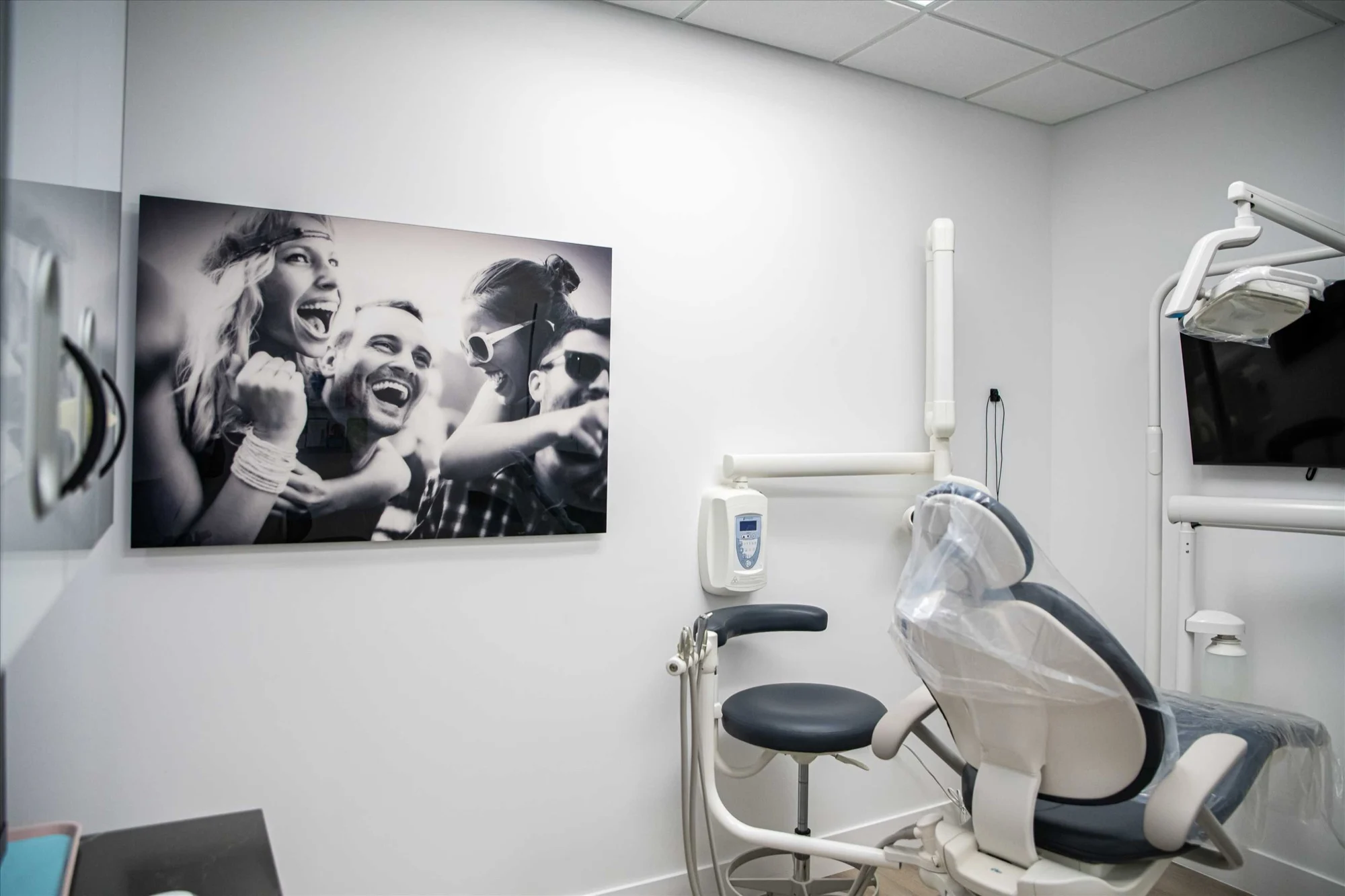 Select Dental Care — Sala de tratamiento con una fotografía en blanco y negro de amigos riendo, junto al sillón dental