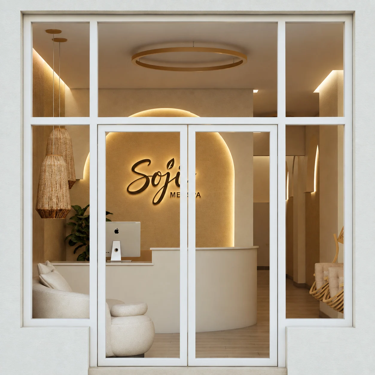 Soji Medspa — Storefront seen through white-framed glass doors, with a curved reception desk under a backlit arch, a script sign and woven pendant lamps